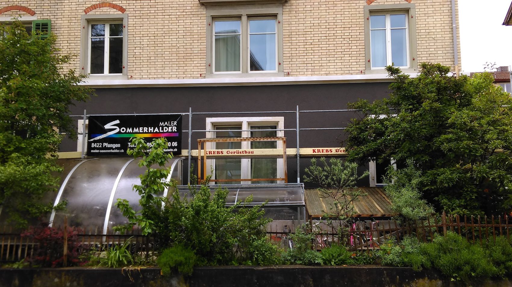 Hausfassade mit Gerüst und Firmenbanner von Maler Sommerhalder